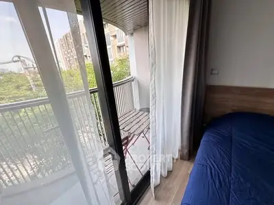 Cozy bedroom with balcony view in modern apartment, featuring natural light and stylish decor.