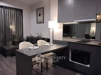 Modern open-plan kitchen and living area with sleek design and cozy dining space.