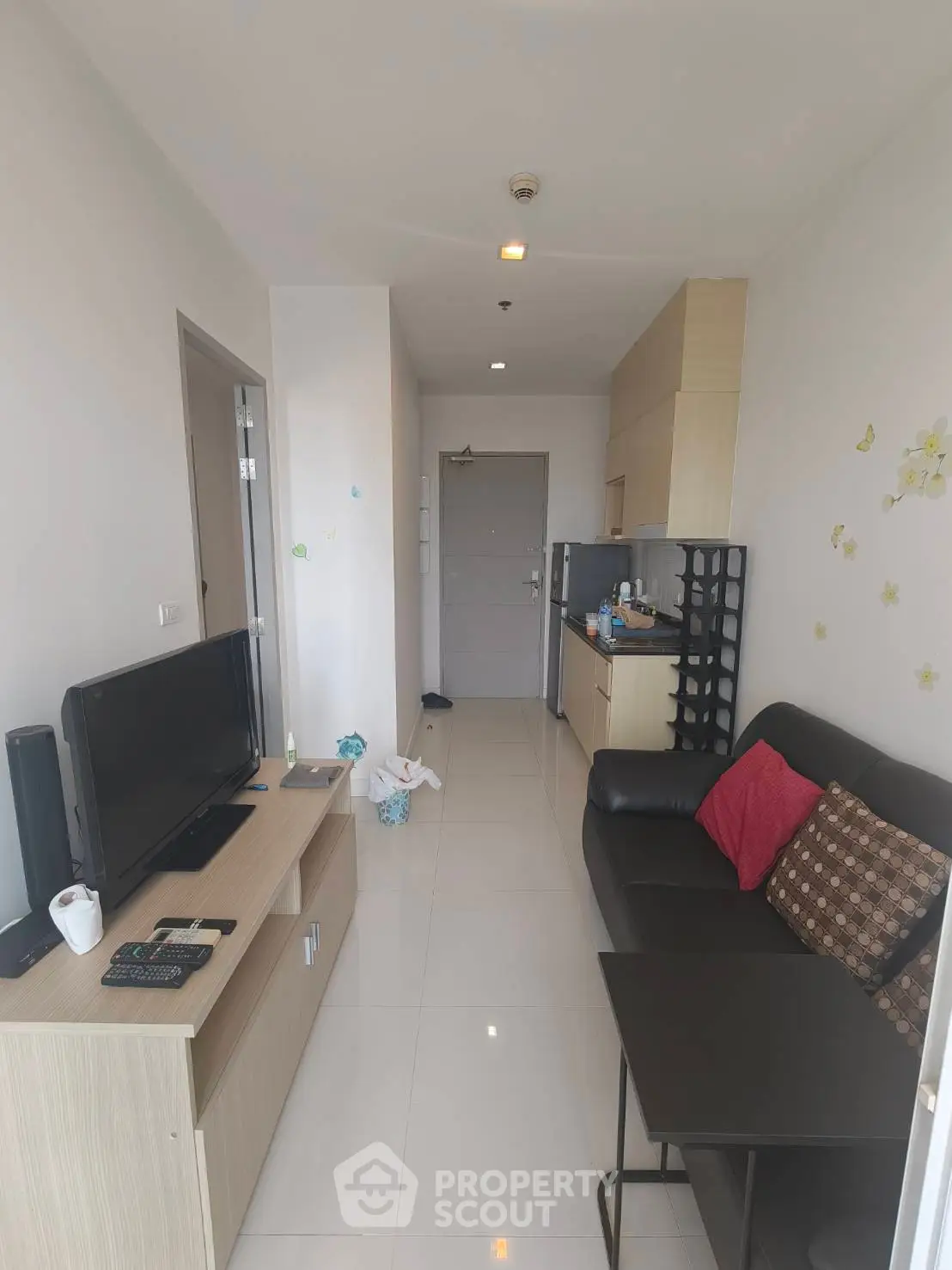 Modern living room with sleek furniture and open kitchen layout in a cozy apartment.