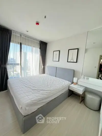 Modern bedroom with large windows and elegant decor in a high-rise apartment.