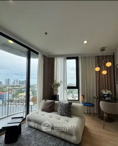 Modern living room with panoramic city view, stylish furniture, and cozy ambiance in a high-rise apartment.