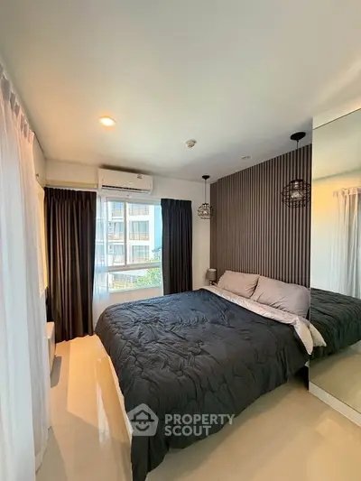 Modern bedroom with stylish decor and large window in a contemporary apartment.