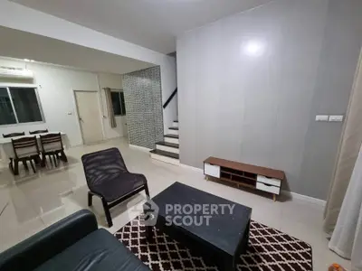 Spacious modern living room with sleek furniture and open dining area, perfect for family gatherings.