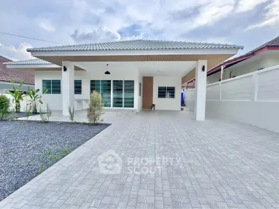 Modern single-story house with spacious driveway and sleek design