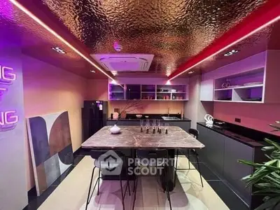 Modern kitchen with LED lighting, marble dining table, and high-end appliances, perfect for culinary enthusiasts looking for a stylish cooking space.