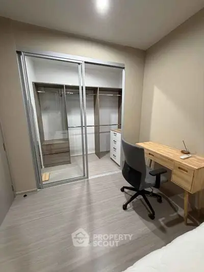Modern study room with sleek desk and chair, featuring a spacious walk-in closet with sliding glass doors.