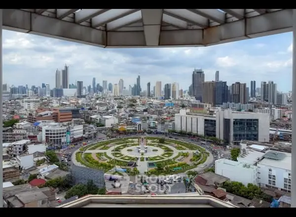 Stunning cityscape view from a high-rise building showcasing urban skyline and circular park below.