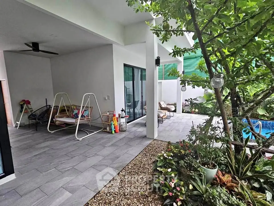 Charming outdoor patio with lush garden and cozy seating area, perfect for relaxation and entertaining.