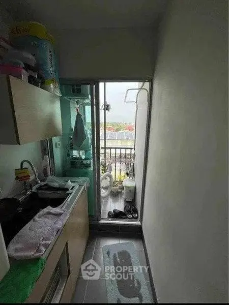 Compact kitchen with balcony view, featuring modern appliances and efficient layout.