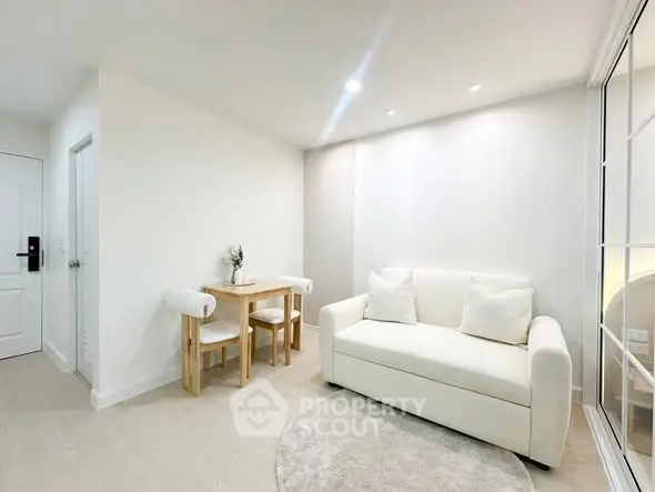 Bright and cozy living room with modern white sofa and dining area, perfect for relaxation and entertaining.