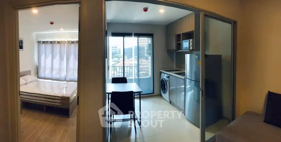 Modern apartment with open kitchen, dining area, and bedroom with large windows.