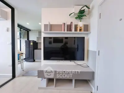 Modern living room with sleek TV unit and open kitchen view