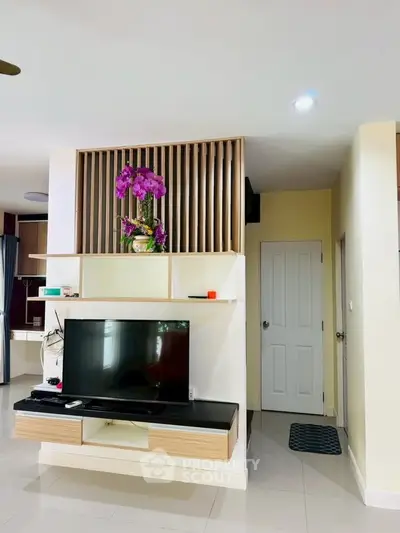 Modern living room with sleek TV stand and vibrant orchid decor