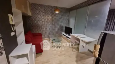 Modern living room with red sofa, glass coffee table, and TV unit in stylish apartment.