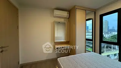 Modern bedroom with city view, featuring built-in wardrobe and air conditioning.