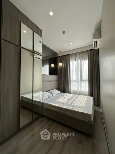 Modern bedroom with mirrored wardrobe and natural light