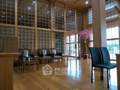 Spacious wooden interior with elegant seating and large windows, perfect for a serene living room or lobby.