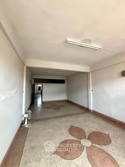 Spacious interior with unique floral floor design, ideal for creative renovation in a residential property.