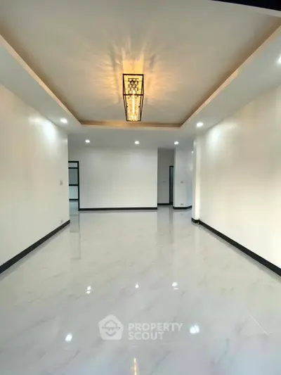 Spacious modern living room with elegant lighting and glossy marble flooring