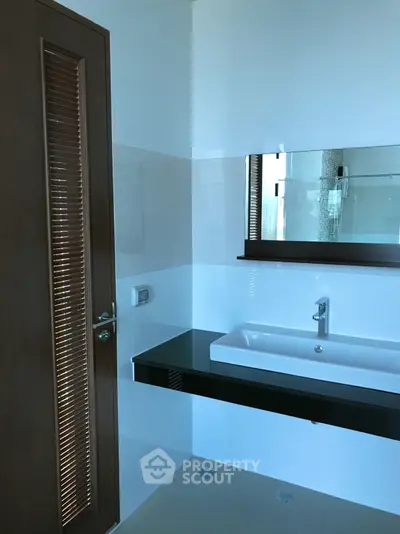 Modern bathroom with sleek sink and large mirror in a stylish home.