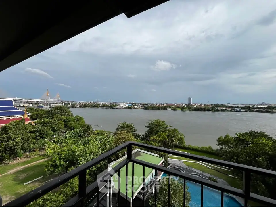 Stunning river view from a high-rise balcony overlooking lush greenery and cityscape.