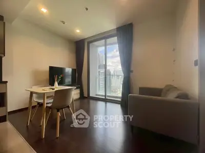 Modern living room with city view, featuring sleek furniture and large windows.