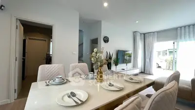 Elegant modern living room with dining area, stylish decor, and natural light from large windows.