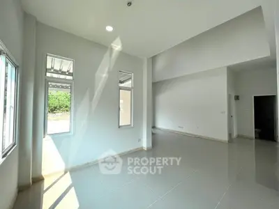 Spacious modern living room with large windows and abundant natural light