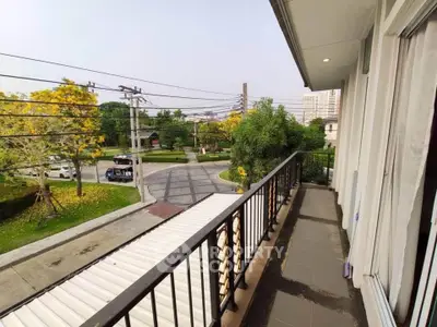 Spacious balcony with scenic view of lush greenery and urban surroundings, perfect for relaxation.