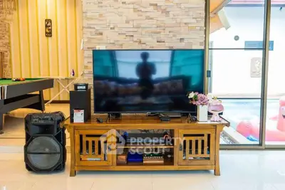 Stylish living room with modern TV setup and pool table, perfect for entertainment.