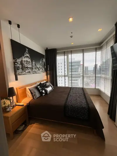 Luxurious bedroom with city view, modern decor, and floor-to-ceiling windows in high-rise apartment.