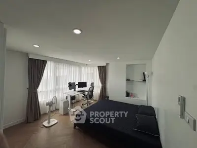 Modern bedroom with workspace and large windows in a stylish apartment