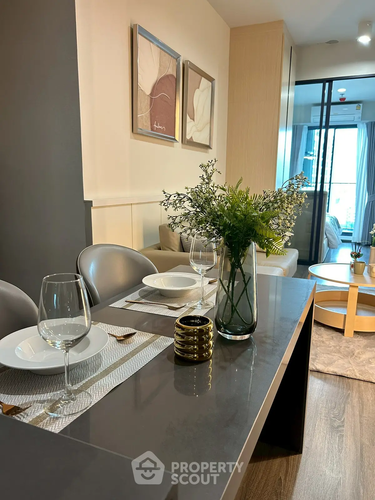 Modern dining area with elegant table setting and cozy living room view.