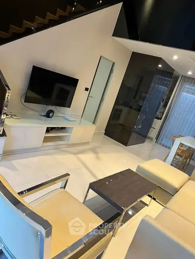 Modern living room with sleek furniture and wall-mounted TV in stylish home