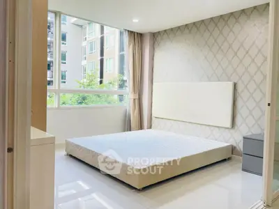 Modern bedroom with large window and stylish wallpaper in a high-rise apartment.