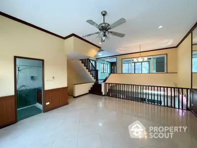 Spacious multi-level home with gleaming tile floors, elegant staircase, and modern ceiling fan, perfect for comfortable living and entertaining.