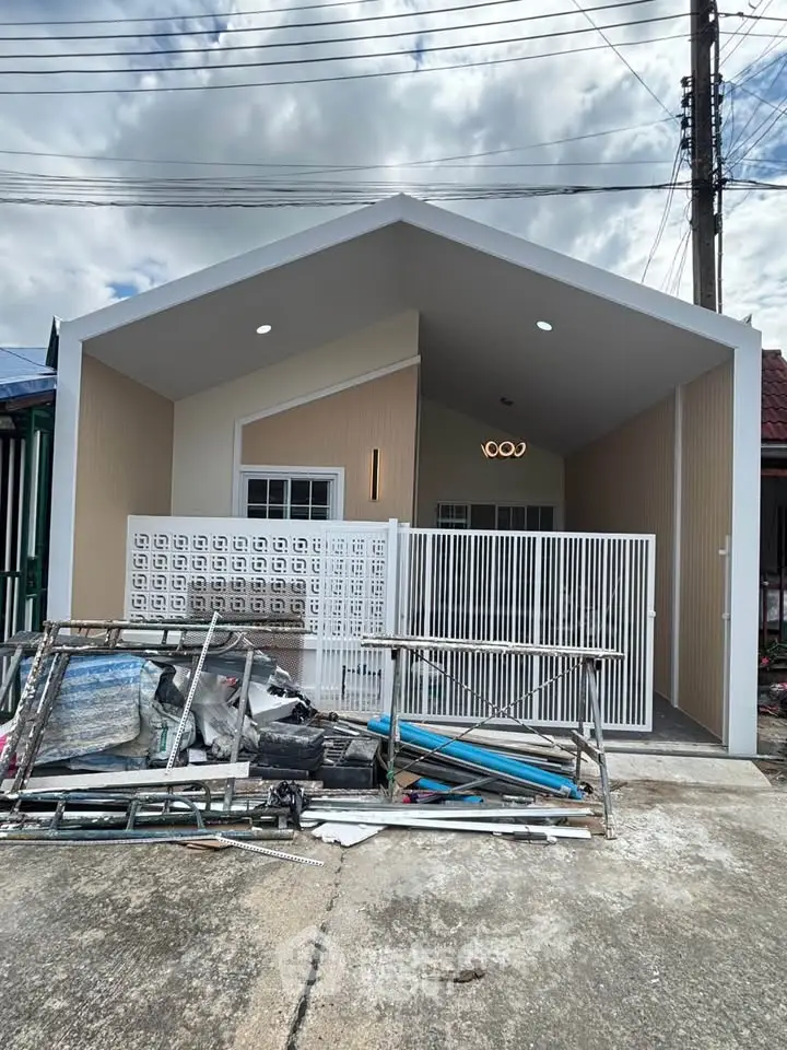 Modern minimalist house exterior with unique geometric design and gated entrance.