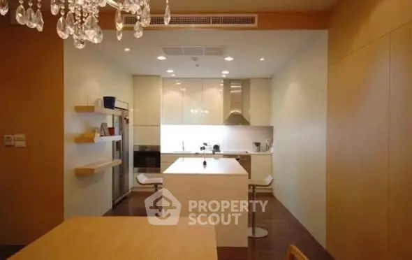 Modern kitchen with sleek design and open layout, featuring a central island and elegant lighting.