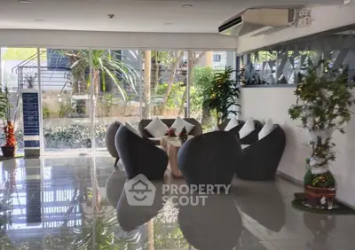 Modern lobby with stylish seating and large windows offering garden views.