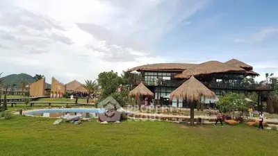 Charming rustic resort with thatched roofs and lush green surroundings, perfect for a serene getaway.