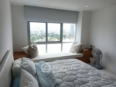 Bright bedroom with large window and city view, featuring cozy bed and modern decor.