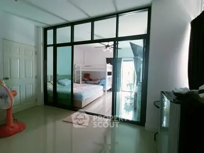 Spacious bedroom with bunk beds and modern glass partition, ideal for family living.