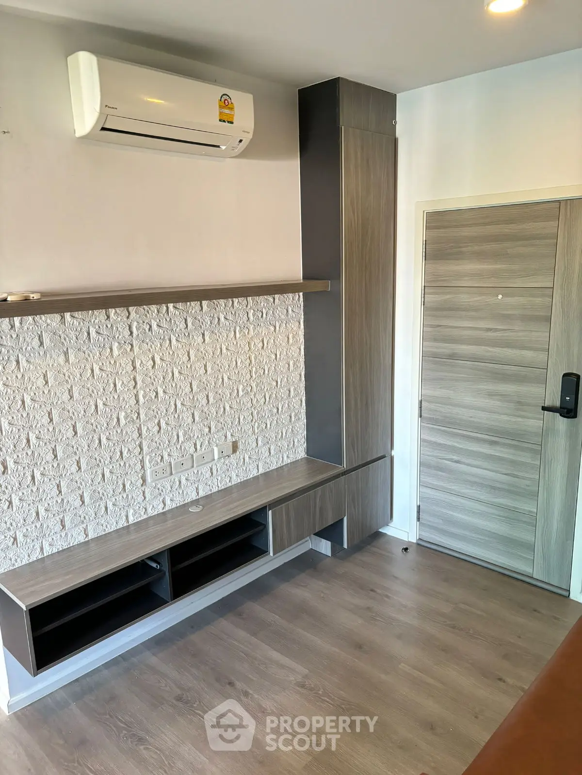 Modern living room with sleek wooden flooring and built-in storage unit.