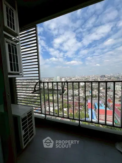 Stunning high-rise balcony view overlooking cityscape with clear blue skies.
