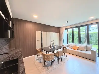 Modern living room with elegant dining area and large windows overlooking garden