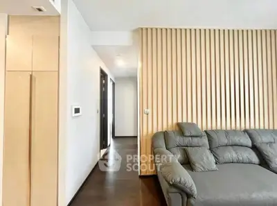 Modern living room with stylish grey sofa and wooden accent wall