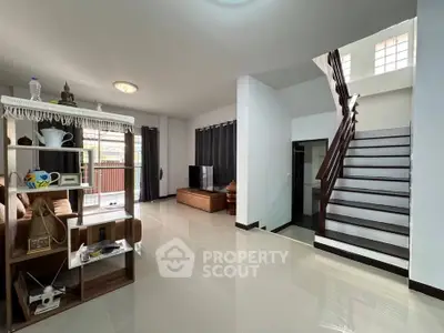 Spacious modern living room with sleek staircase and open layout, perfect for family gatherings.
