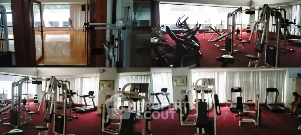 Spacious gym with modern fitness equipment and large windows for natural light.