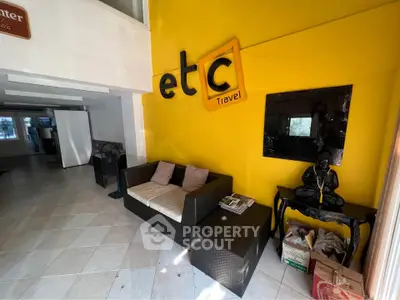 Modern office lobby with vibrant yellow wall and stylish seating area.