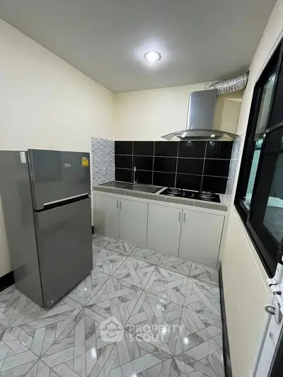 Modern kitchen with sleek appliances and stylish tile flooring